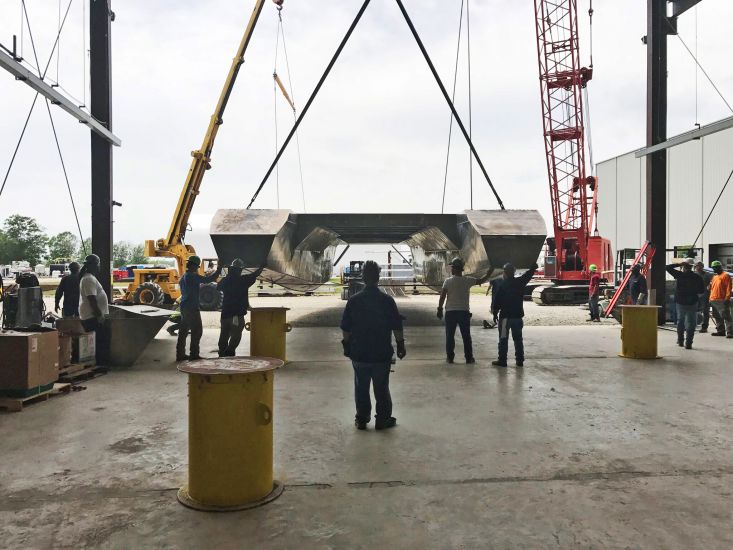 The completed hull of Potomac Taxi I is flipped via crane.